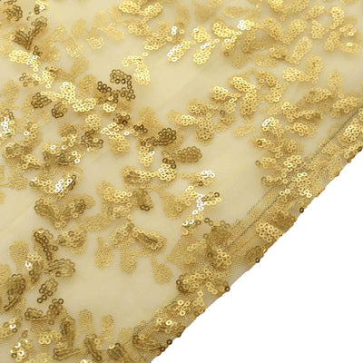Gold sequin fabric with intricate floral design on a beige background.