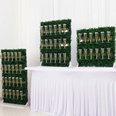 Champagne display on greenery backdrop at an event.