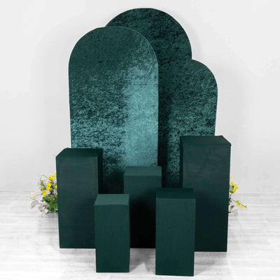 Green velvet display stands in various heights against a white backdrop.