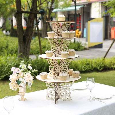 Elegant cupcake stand with decorative layers, displayed outdoors with floral arrangement.