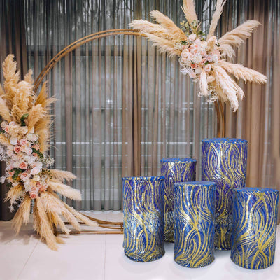 Decorative blue and gold vases displayed with floral arch backdrop.