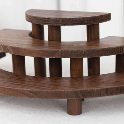 Wooden decorative step display stand on a neutral background.