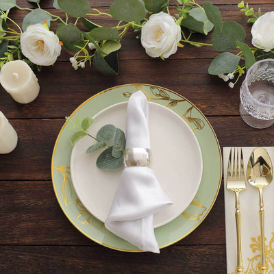 Elegant table setting with white napkin, decorative plate, and floral accents.