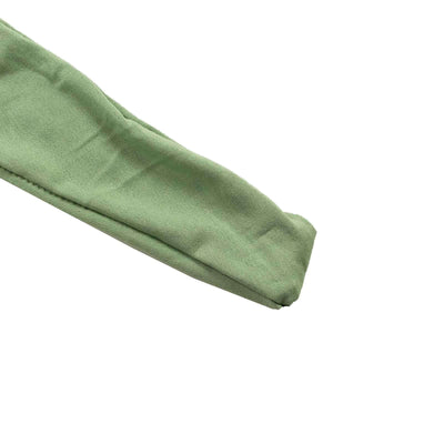 Green fabric sleeve on a plain backdrop