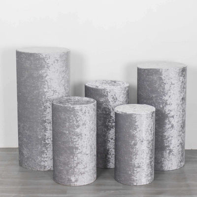 Set of five gray velvet display pedestals in various heights.