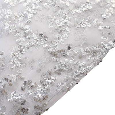 Silver sequin fabric with intricate floral pattern on sheer material.