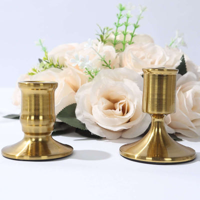 Brass candle holders with floral arrangement in background.