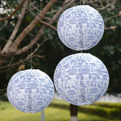 Blue and white patterned hanging paper lanterns in an outdoor setting.