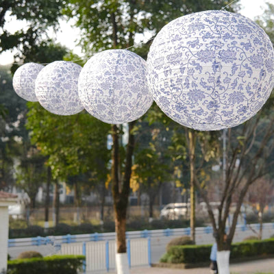 Blue and white decorative paper lanterns hanging outdoors.