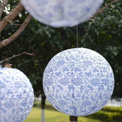 Blue floral patterned paper lanterns hanging outdoors.