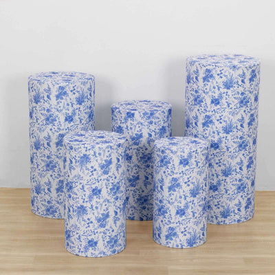 Decorative blue floral cylindrical storage containers on a light wooden floor.