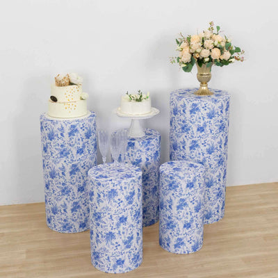 Decorative floral display pedestals arranged with cakes and flowers.