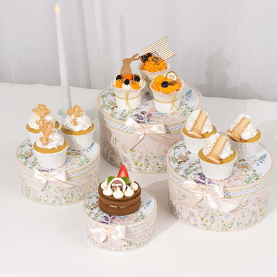 Decorative cupcakes on elegant floral boxes, styled for a celebration.
