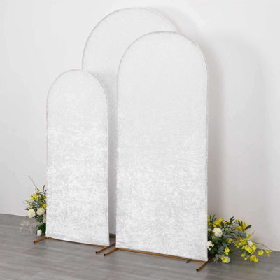 Three elegant arched backdrop screens with floral accents in a studio setting.