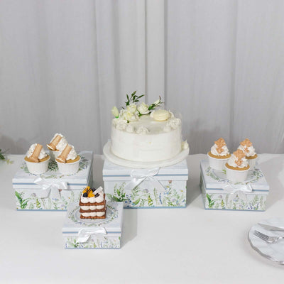 Elegant wedding cake and cupcakes on floral gift boxes.