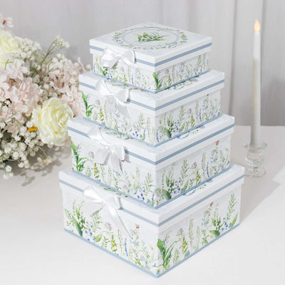 Decorative floral gift boxes stacked with ribbons on a table.
