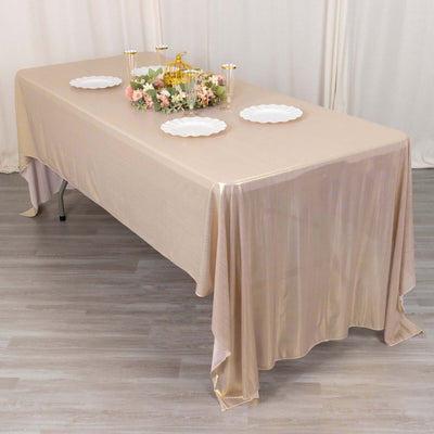 Elegant beige tablecloth draped over a table with decorative floral centerpiece.