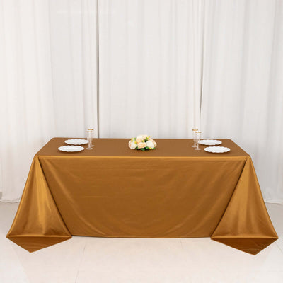 Brown tablecloth draped over a table set for dining with plates and floral centerpiece.