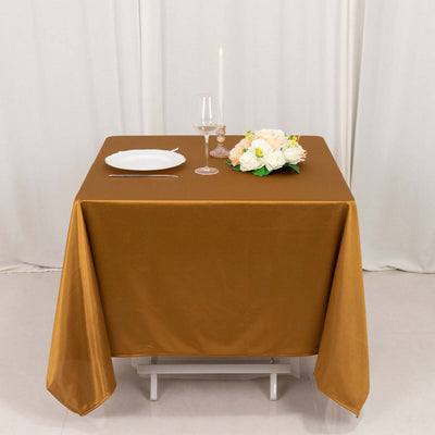 Brown tablecloth with set dining arrangement and floral centerpiece.