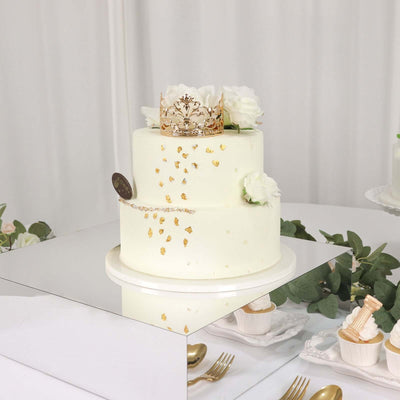 Elegant two-tier wedding cake adorned with gold accents and white floral decorations.