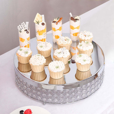 Assorted desserts on a mirrored cake stand, showcasing colorful treats and decorations.
