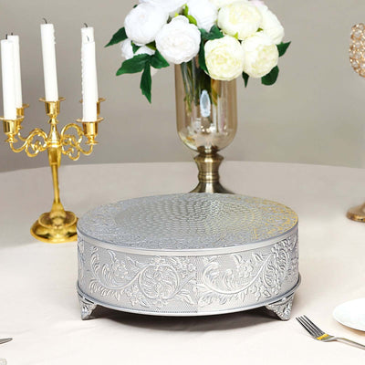 Elegant silver cake stand with intricate floral design on a table setting.