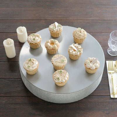 Elegant cupcakes decorated with white frosting and floral accents on a silver stand.