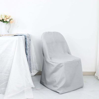 Gray chair cover on a plain background with a table setting nearby.