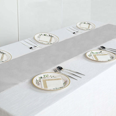 Elegant dinner table setting with patterned plates and cutlery.