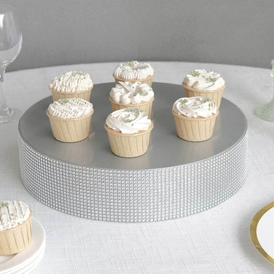 Decorative cupcakes on a silver cake stand in a minimalist setting.