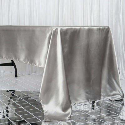 Silver satin tablecloth draping elegantly on a table