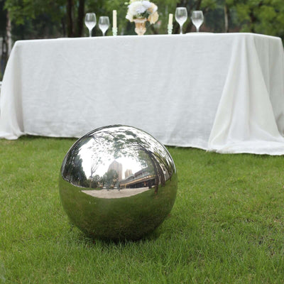 Reflective garden sphere on grass near a table setting.
