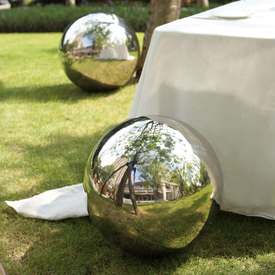 Reflective garden decor spheres on grass.