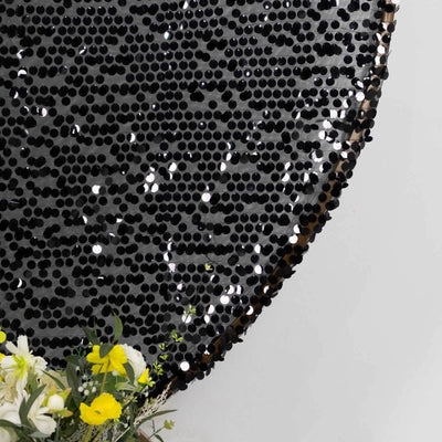 Black sequin round table top with floral arrangement
