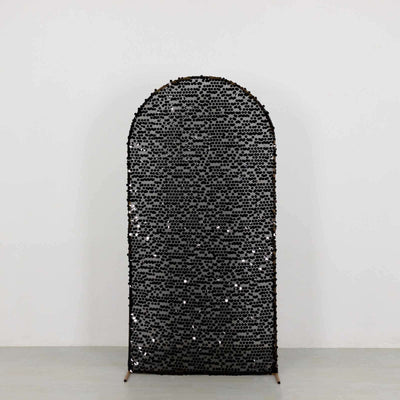 Decorative black sequined arch mirror on a simple backdrop.