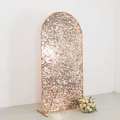 Rose gold sequin backdrop with floral arrangement in front.