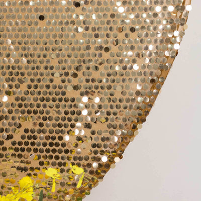Gold sequin fabric with shimmering details and yellow flowers.