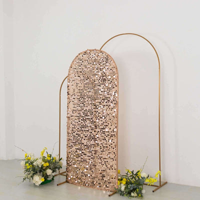 Rose gold sequin backdrop with gold arch and floral arrangements.