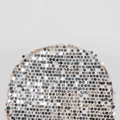 Silver sequin circular decor piece on a plain background