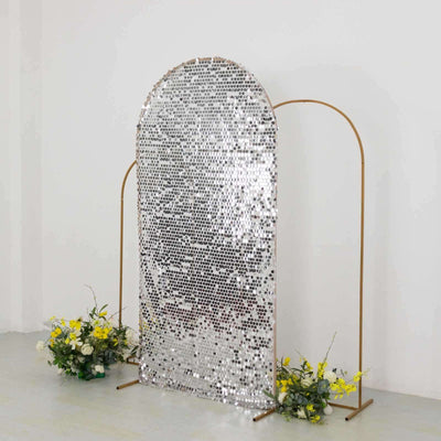 Silver sequin backdrop with gold frame and flowers at the base.