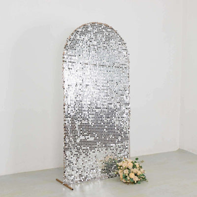 Arched silver mirror with floral arrangement in front