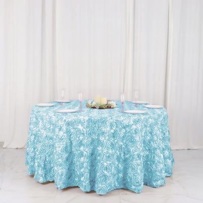 Elegant blue rose-patterned tablecloth on a round table set for dining.