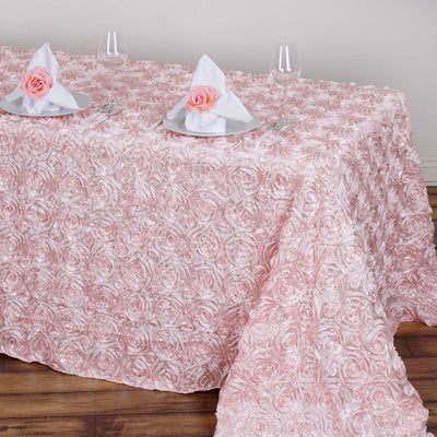 Pink rose-patterned tablecloth draped over a table set for dining.