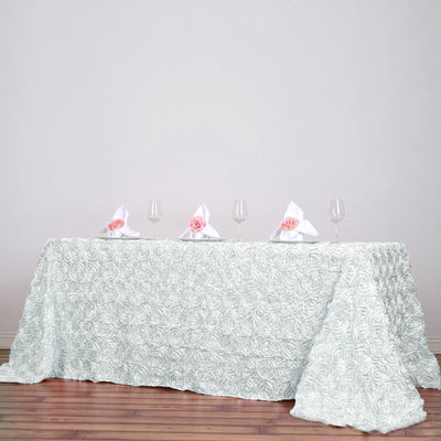 Elegant mint rose-patterned tablecloth with wine glasses and napkins.