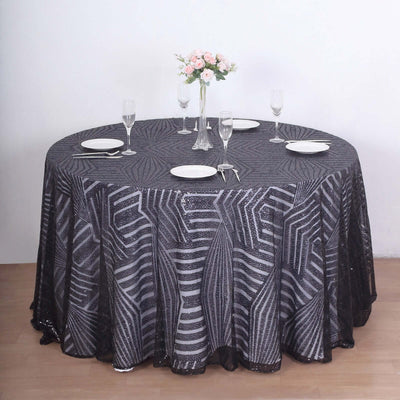 Black and silver patterned tablecloth on a round table with floral centerpiece.
