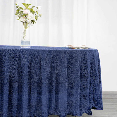 Navy tablecloth with textured pattern draping over a table with flowers