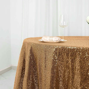 Gold sequin tablecloth with a glass and napkin on a table.