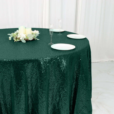Green sequined tablecloth draped on a round table with decorative accents.