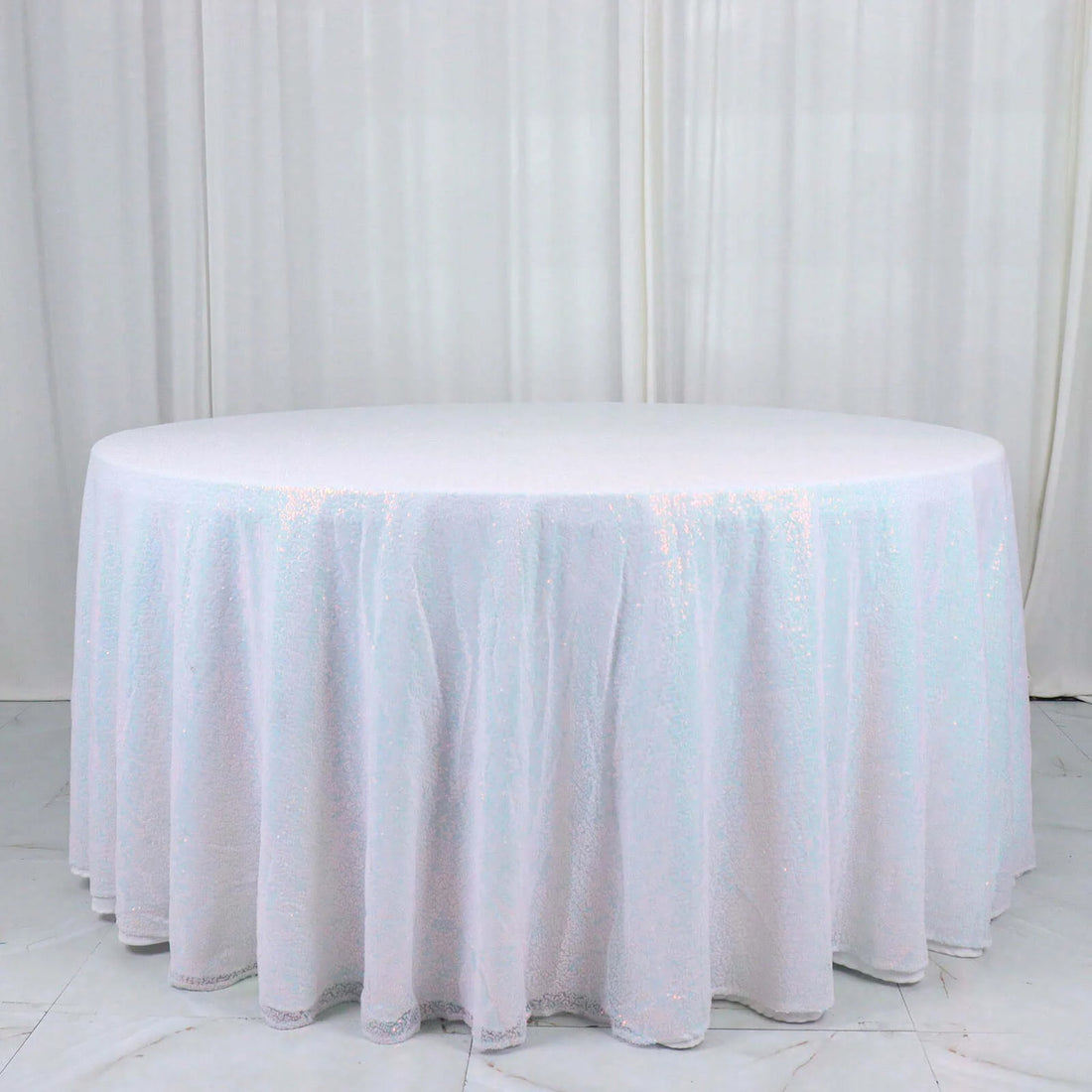 Round iridescent sequin tablecloth on a white backdrop