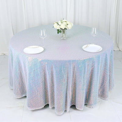Round iridescent tablecloth on a dining table with plates and glasses